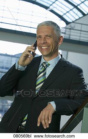 portrait of mature businessman listening to mobile phone View Large Photo Image Stock Image - portrait of mature businessman listening to mobile phone. Fotosearch