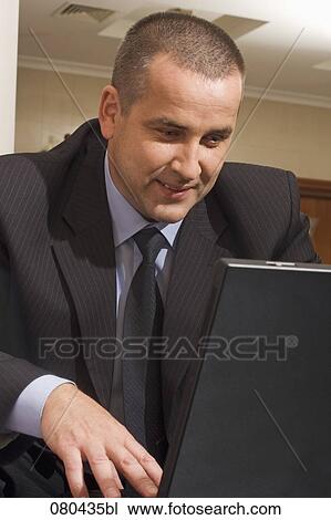 portrait of mature businessman working with laptop computer in hotel lobby View Large Photo Image Stock Image - portrait of mature businessman working with laptop computer in hotel lobby. Fotosearch