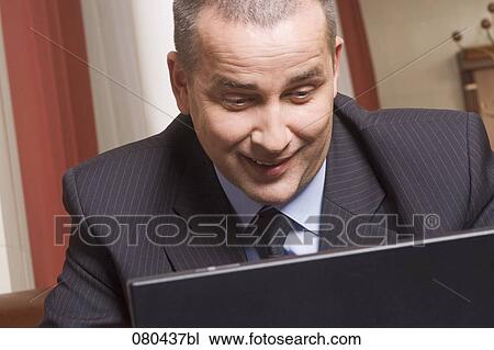 portrait of mature businessman working with laptop computer in hotel lobby View Large Photo Image Stock Image - portrait of mature businessman working with laptop computer in hotel lobby. Fotosearch