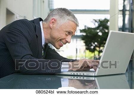 portrait of mature businessman working with laptop computer View Large Photo Image Stock Image - portrait of mature businessman working with laptop computer. Fotosearch