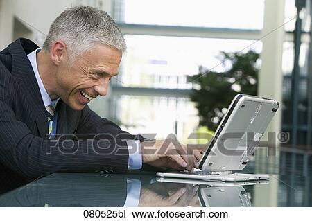 portrait of mature businessman working with laptop computer View Large Photo Image Stock Image - portrait of mature businessman working with laptop computer. Fotosearch