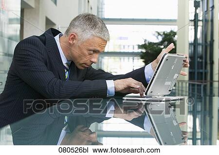 portrait of mature businessman working with laptop computer View Large Photo Image Stock Image - portrait of mature businessman working with laptop computer. Fotosearch