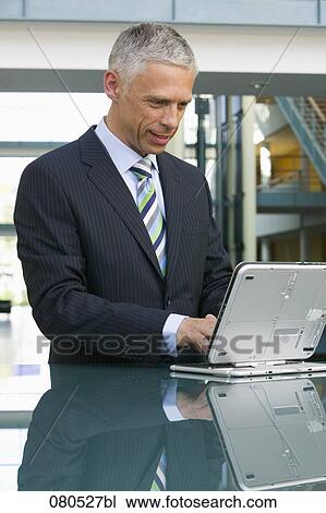 portrait of mature businessman working with laptop computer View Large Photo Image Stock Image - portrait of mature businessman working with laptop computer. Fotosearch
