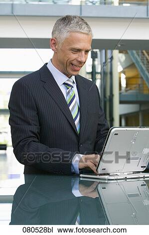 portrait of mature businessman working with laptop computer View Large Photo Image Stock Image - portrait of mature businessman working with laptop computer. Fotosearch