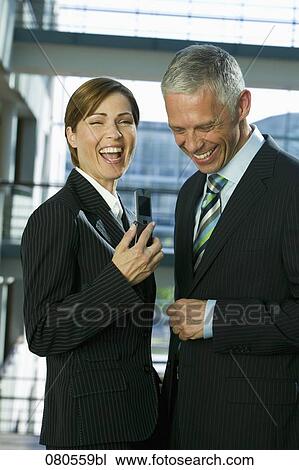 Stock Image - portrait of mature businesswoman and male colleague laughing together. Fotosearch