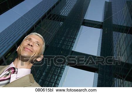 Stock Image - portrait of mature executive in front of office building. Fotosearch