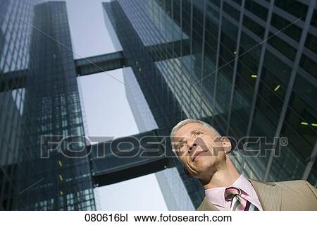 Stock Image - portrait of mature executive in front of office building. Fotosearch