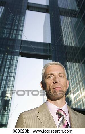 Stock Image - portrait of mature executive in front of office building. Fotosearch