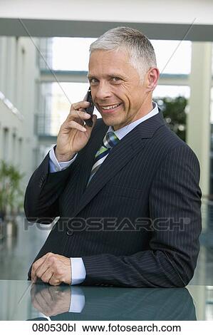 Stock Image - portrait of mature executive talking on mobile phone. Fotosearch