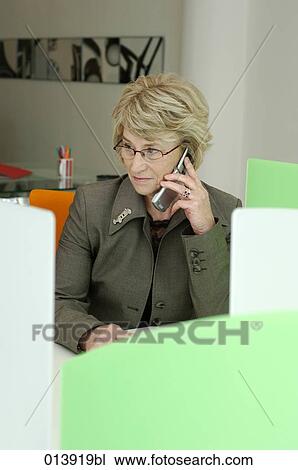 portrait of mature woman talking on cellular phone in office View Large Photo Image Stock Image - portrait of mature woman talking on cellular phone in office. Fotosearch