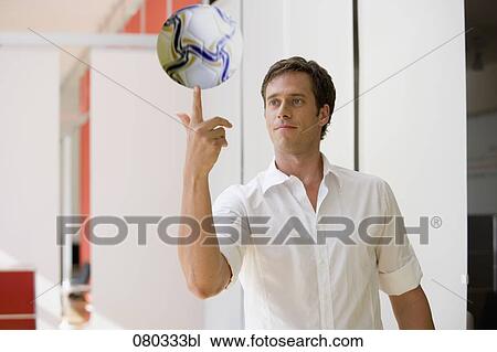 portrait of office worker balancing football on finger View Large Photo Image Stock Image - portrait of office worker balancing football on finger. Fotosearch