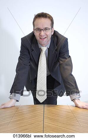portrait of optimistic looking businessman leaning on table View Large Photo Image Stock Image - portrait of optimistic looking businessman leaning on table. Fotosearch