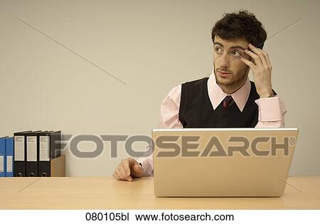 portrait of pensive businessman sitting behind laptop computer View Large Photo Image Stock Image - portrait of pensive businessman sitting behind laptop computer. Fotosearch