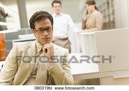 portrait of serious businessman sitting at desk in office space View Large Photo Image Stock Image - portrait of serious businessman sitting at desk in office space. Fotosearch