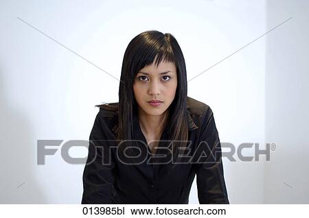 Stock Image - portrait of serious looking asian office worker. Fotosearch