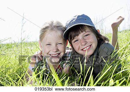 portrait of sister and brother reaxing in grass View Large Photo Image Stock Image - portrait of sister and brother reaxing in grass. Fotosearch