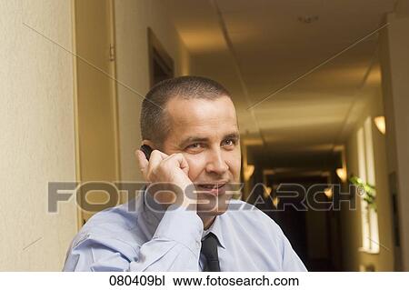 portrait of smiling mature businessman in hotel corridor talking on mobile phone View Large Photo Image Stock Image - portrait of smiling mature businessman in hotel corridor talking on mobile phone. Fotosearch