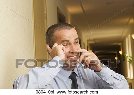 portrait of smiling mature businessman in hotel corridor talking on mobile phone View Large Photo Image Stock Image - portrait of smiling mature businessman in hotel corridor talking on mobile phone. Fotosearch