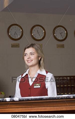 Stock Image - portrait of smiling young receptionist at hotel. Fotosearch