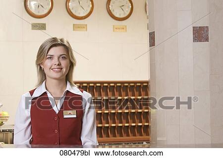 Stock Image - portrait of smiling young receptionist at hotel. Fotosearch