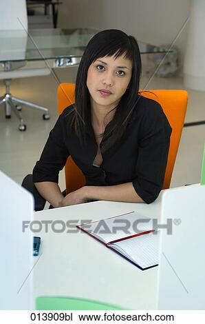 Stock Image - portrait of young asian woman in office space. Fotosearch