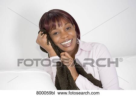 portrait of young black woman sitting on sofa holding blanket View Large Photo Image Stock Image - portrait of young black woman sitting on sofa holding blanket. Fotosearch