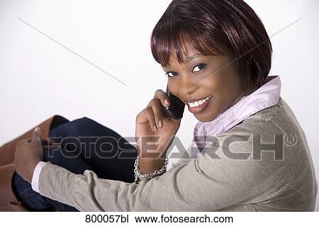 Stock Image - portrait of young black woman talking on mobile phone. Fotosearch