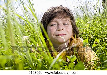 portrait of young boy lying in grass View Large Photo Image Stock Image - portrait of young boy lying in grass. Fotosearch