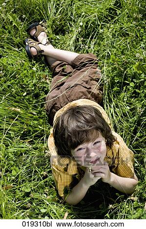 portrait of young boy lying in grass View Large Photo Image Stock Image - portrait of young boy lying in grass. Fotosearch