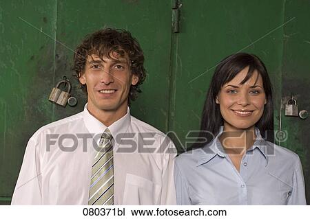 Stock Image - portrait of young businessman and businesswoman standing side by side. Fotosearch