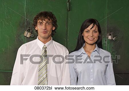 Stock Image - portrait of young businessman and businesswoman standing side by side. Fotosearch