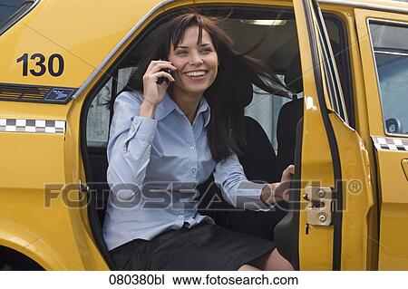 portrait of young businesswoman leaving yellow taxi talking on mobile phone View Large Photo Image Stock Image - portrait of young businesswoman leaving yellow taxi talking on mobile phone. Fotosearch