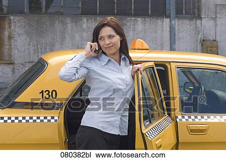 portrait of young businesswoman leaving yellow taxi talking on mobile phone View Large Photo Image Stock Image - portrait of young businesswoman leaving yellow taxi talking on mobile phone. Fotosearch