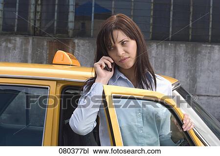 portrait of young businesswoman standing at open door of yellow taxi listening to mobile phone View Large Photo Image Stock Image - portrait of young businesswoman standing at open door of yellow taxi listening to mobile phone. Fotosearch