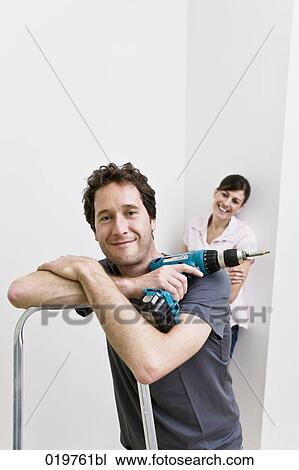 portrait of young couple in new home man holding cordless screwdriver View Large Photo Image Stock Image - portrait of young couple in new home man holding cordless screwdriver. Fotosearch