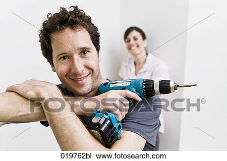 portrait of young couple in new home man holding cordless screwdriver View Large Photo Image Stock Image - portrait of young couple in new home man holding cordless screwdriver. Fotosearch