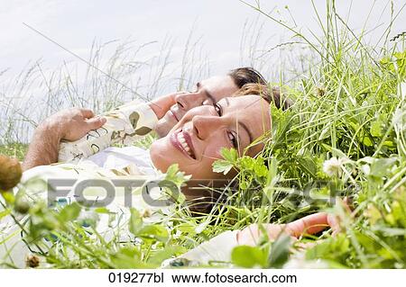 portrait of young couple relaxing in grass View Large Photo Image Stock Image - portrait of young couple relaxing in grass. Fotosearch