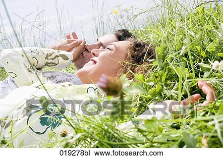 portrait of young couple relaxing in grass View Large Photo Image Stock Image - portrait of young couple relaxing in grass. Fotosearch