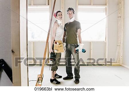 portrait of young couple standing in construction site of new home View Large Photo Image Stock Image - portrait of young couple standing in construction site of new home. Fotosearch