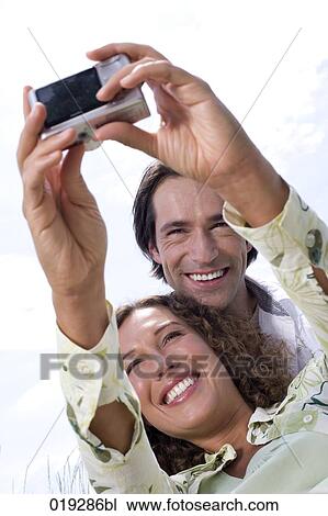 portrait of young couple taking portrait of themselves with digital camera View Large Photo Image Stock Image - portrait of young couple taking portrait of themselves with digital camera. Fotosearch
