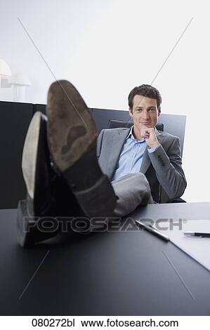 portrait of young entrepreneur sitting with his feet on desk View Large Photo Image Stock Image - portrait of young entrepreneur sitting with his feet on desk . Fotosearch