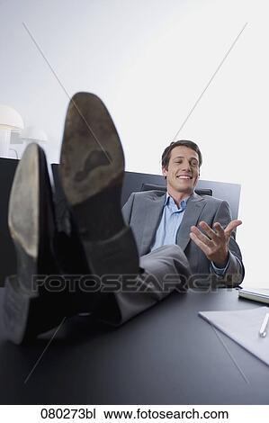 portrait of young entrepreneur sitting with his feet on desk View Large Photo Image Stock Image - portrait of young entrepreneur sitting with his feet on desk . Fotosearch