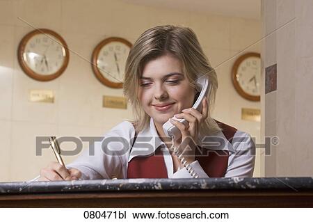 portrait of young hotel receptionist talking on telephone and taking down notes View Large Photo Image Stock Image - portrait of young hotel receptionist talking on telephone and taking down notes. Fotosearch