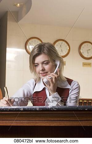 portrait of young hotel receptionist talking on telephone and taking down notes View Large Photo Image Stock Image - portrait of young hotel receptionist talking on telephone and taking down notes. Fotosearch