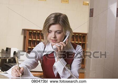 portrait of young hotel receptionist talking on telephone and taking down notes View Large Photo Image Stock Image - portrait of young hotel receptionist talking on telephone and taking down notes. Fotosearch