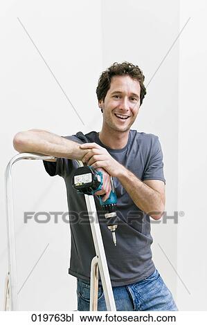 portrait of young man with cordless screwdriver leaning against ladder View Large Photo Image Stock Image - portrait of young man with cordless screwdriver leaning against ladder. Fotosearch