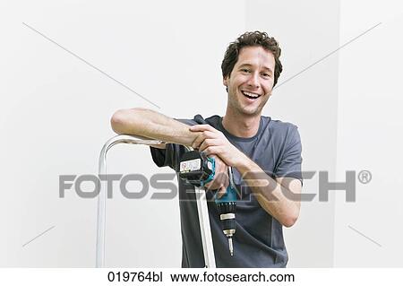 portrait of young man with cordless screwdriver leaning against ladder View Large Photo Image Stock Image - portrait of young man with cordless screwdriver leaning against ladder. Fotosearch