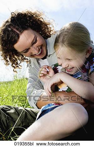 portrait of young mother tickling her daughter View Large Photo Image Stock Image - portrait of young mother tickling her daughter. Fotosearch