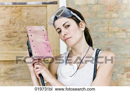 portrait of young woman holding sanding machine View Large Photo Image Stock Image - portrait of young woman holding sanding machine. Fotosearch