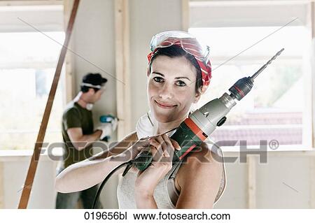 portrait of young woman holding electric drill View Large Photo Image Stock Image - portrait of young woman holding electric drill. Fotosearch